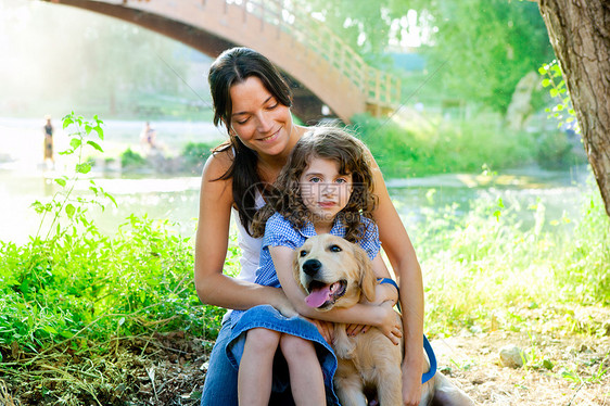 女儿和母亲有金色的采金机友谊蓝色女孩女性动物幸福公园姐姐猎犬童年图片