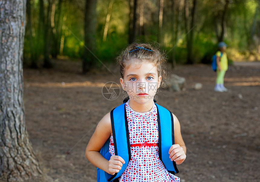 女童在森林中带着背背包徒步旅行图片