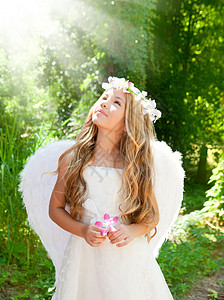 森林中的天使女孩 手握花朵的女孩图片