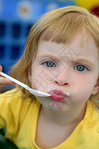 金发的小女孩 吃和游荡营养头发金发女郎孩子女孩勺子饮食手势食物女性图片