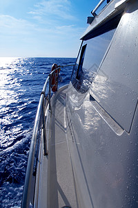 在蓝海太阳反射中航行的船边帆图片