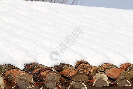 年老的泥土屋顶瓷砖在冬季雪下下下雪房子住宅村庄建筑学财产滑雪黏土框架建筑城市图片