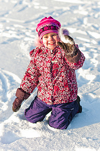 婴儿坐在雪上微笑图片