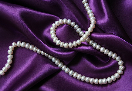 白珍珠 以丝绸上的白珍珠为背景魅力宝石象牙手镯珠宝珠子项链细绳礼物紫丁香图片