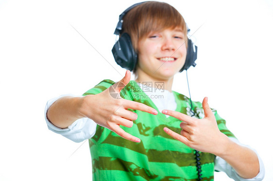 一位男性青少年听音乐的肖像瞳孔享受耳机爱好宏观歌曲音乐播放器有声读物微笑黑色图片
