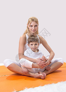一个美丽的年轻母亲 和儿子一起做瑜伽女性金发女郎头发童年姿势幸福婴儿水平运动身体图片