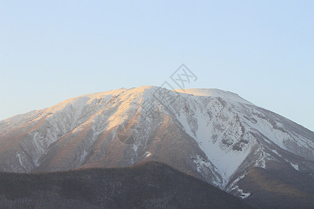 以岩瓦特山对抗蓝天粉雪朝霞雪原阴影图片