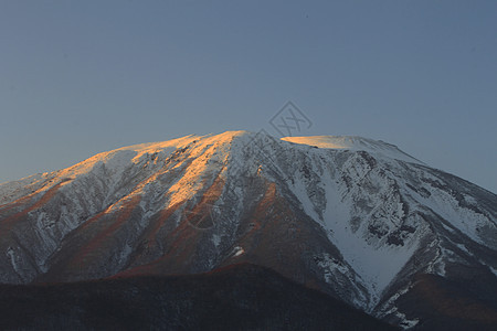 以岩瓦特山对抗蓝天雪原阴影朝霞粉雪图片