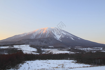 以岩瓦特山对抗蓝天粉雪朝霞雪原阴影图片