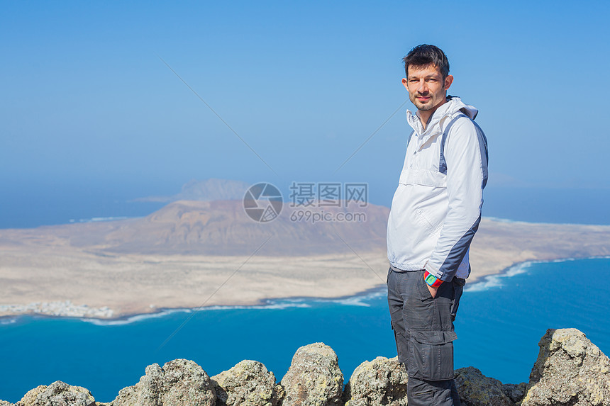 人类站在悬崖边缘的景象天空运动背包远足岩石顶峰石头高度男生冒险图片