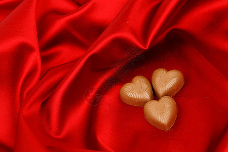 红沙子上的糖果心盒子食物丝带展示巧克力正方形甜点礼物生日奢华图片