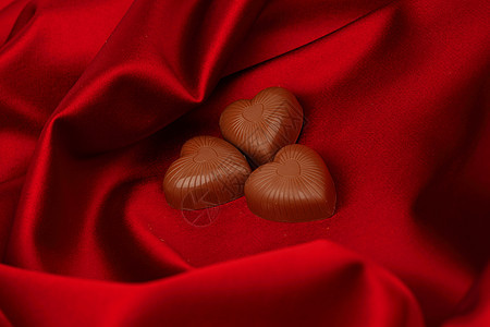 红沙子上的糖果心生日小吃礼物奢华食物巧克力丝带正方形标签织物图片