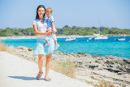 沿热带沙滩步行的家庭游艇喜悦海洋儿子父母异国幸福乐趣海岸线妈妈图片