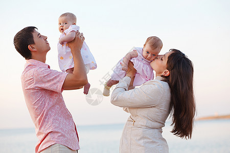 有子女的年幼父母微笑女孩们女儿们童年新生儿家庭生活双胞胎拥抱育儿图片