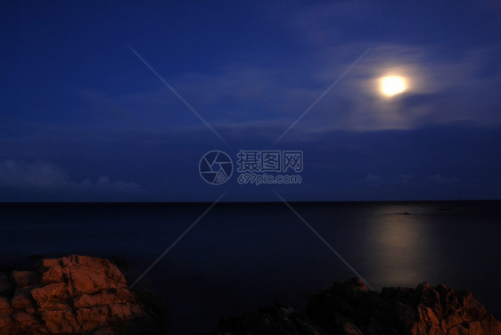 月亮在海面上反射天空岩石黑暗月光照明海岸海景海洋图片