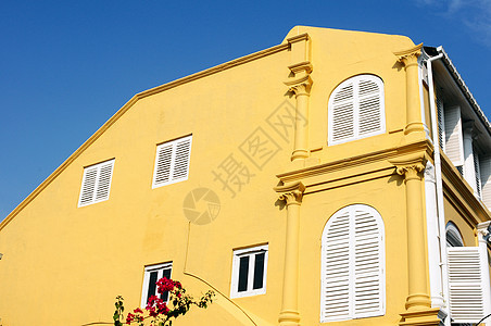 旧建筑的黄墙历史性白色装饰天空蓝色风格建筑学房子窗户图片