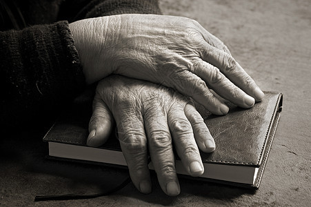 旧手在圣经上桌子女士笔记本手指宗教老化皮肤皱纹成人图片