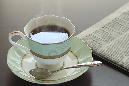 一杯热咖啡和报纸桌子黑色白色杯子早餐休息勺子咖啡咖啡店图片