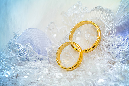 金色的结婚戒指在蕾带上订婚宏观丝绸珠宝已婚庆典联盟夫妻浪漫蕾丝图片