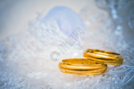 金色的结婚戒指在蕾带上宏观订婚合金浪漫宝石庆典联盟已婚丝绸珠宝图片