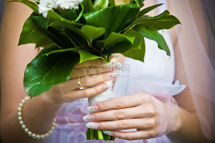 新娘抱着她的花束玫瑰衣服庆典已婚美丽美甲婚姻戒指柔软度仪式图片