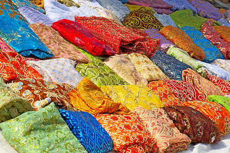 突尼斯市场上的纺织业文化刺绣零售编织织物橙子摊位绣花衣服棉布图片
