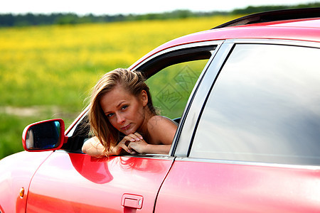 妇女乘坐红色车女性销售奢华眼睛青年运动金发钥匙太阳镜波浪图片