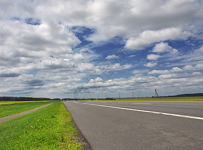 蓝色云天下的高速公路绿色村庄条纹灰色旅行白色路线照片森林乡村图片