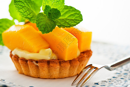 白底带芒果和香草布丁的法国塔特水果面包蓝色食物糖果盘子蛋糕餐厅美食糕点图片