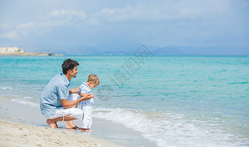 快乐的父亲和儿子在海滩玩耍孩子男生男性乐趣家庭假期海洋天空蓝色男人图片