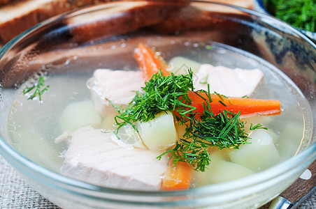 玻璃碗中的鲑鱼汤季节性宏观午餐营养土豆韭葱勺子烹饪美食蔬菜图片