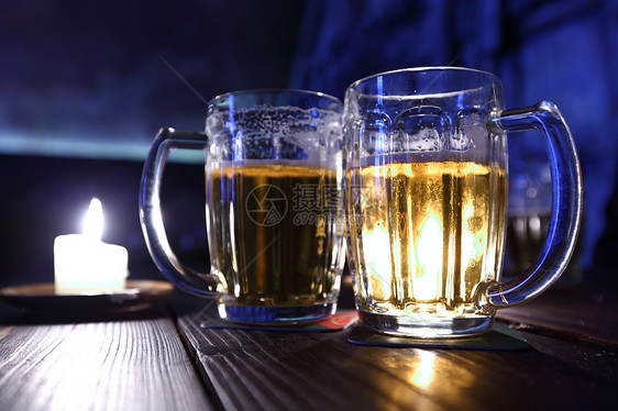 在黑暗中的啤酒火焰气泡琥珀色金子反射生活庆典餐厅酒精泡沫图片