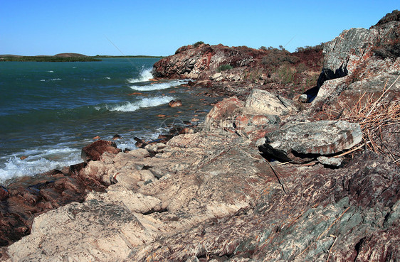 以蓝色海水向地平线驶去的静止海岸图片