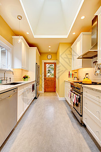 黄色厨房 有白色的橱柜和炉子天花板家电台面凳子冰箱建筑学公寓建筑财产火炉图片