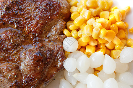 烤猪肉牛排加玉米和小洋葱图片