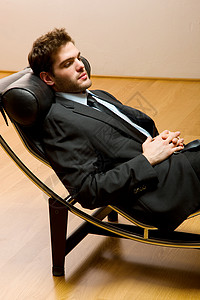 男人躺卧着在发光的长绳上家具职业装躺椅夹克成人领带图片