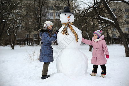 大雪人乐趣童年雪人季节女性幸福女孩白色孩子图片