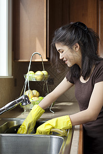 在厨房水池洗碗的少女菜肴洗碗机漂洗女孩孩子手套黄色微笑卫生棕色图片