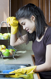 青少年女孩在厨房洗碗池 疲惫的表情图片