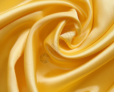 平滑优雅的金色丝绸可用作背景布料织物曲线海浪折痕涟漪黄色投标纺织品材料图片