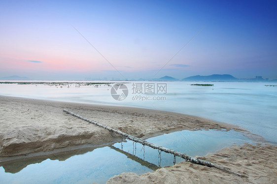 海滩上的热带日落橙子旅行石头天气蓝色地平线海洋季节支撑天空图片