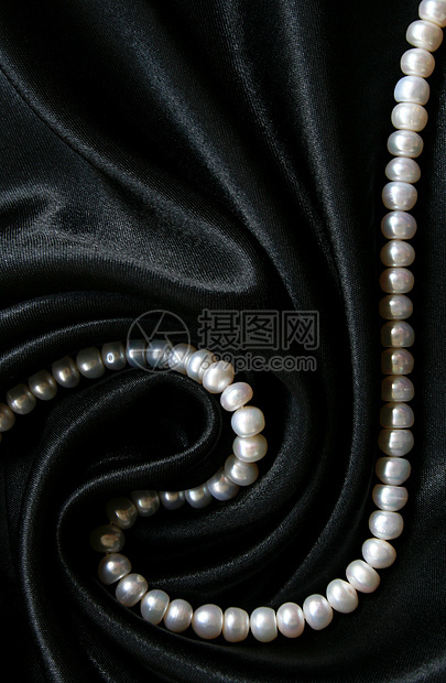 黑色丝绸上的白珍珠作为背景魅力象牙宝石细绳光泽度天鹅绒宝藏反射珍珠展示图片