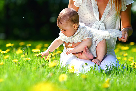 母亲和女儿在绿草上女孩花朵幸福晴天孩子童年女性成人妈妈青年图片