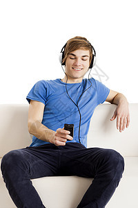 拥有遥控器的人蓝色微笑耳机沙发青年青少年休息喜悦电视手机图片