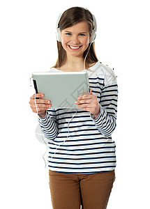 享受音乐的华丽少女冒充美丽立体声快乐微笑女性技术调谐平板电脑图片