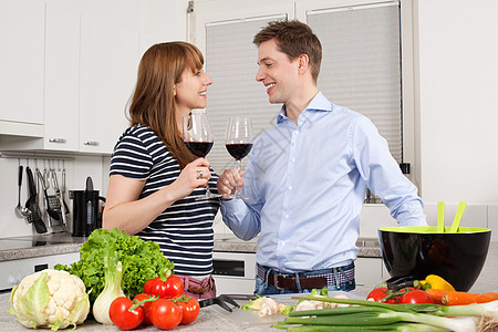 年轻夫妇在厨房喝葡萄酒图片