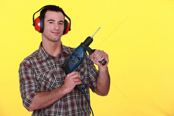 持有电钻的男子职场成人手筒听力人手衣服男性耳机噪音建造图片