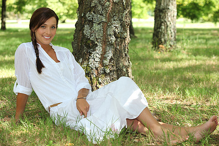身着白衣 坐在树边坐着的女子图片