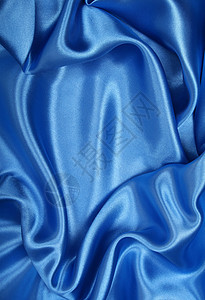 平滑优雅的蓝色丝绸作为背景银色纺织品曲线海浪天蓝色折痕织物投标布料材料图片