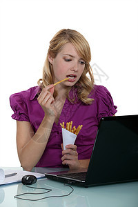女书记员在她办公室吃薯条背景图片